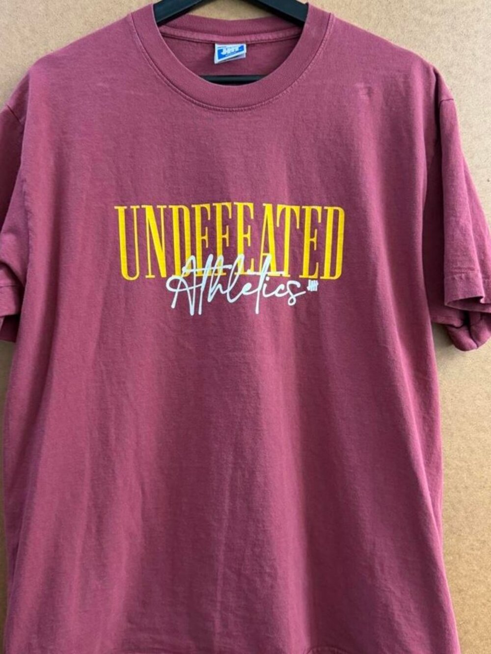 Burgundy Undefeated Athletics T-shirt with yellow and white text graphic